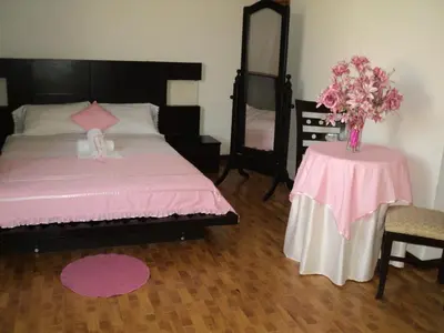 a bedroom with a bed and a table with a vase of flowers at Hotel Conquistadores Inn in Ica