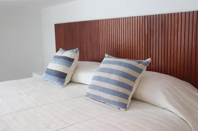 a bed with two blue and white pillows on it at Casa Z Paracas in Paracas