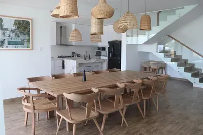 a kitchen and dining room with a wooden table and chairs at Casa Z Paracas in Paracas