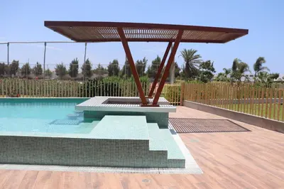 a patio with a table and a swimming pool at Casa Z Paracas in Paracas