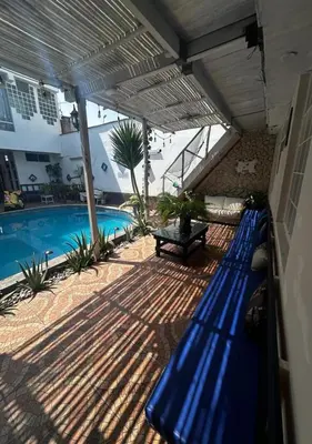 a blue bench on a patio next to a swimming pool at Apartamento Playa Arica in Lurín