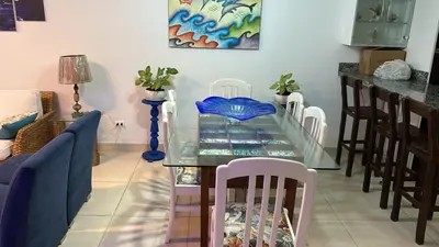 a dining room with a glass table and chairs at Apartamento Playa Arica in Lurín