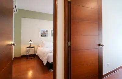 a bedroom with a bed and a wooden door at Narciso 350 by Wynwood House in Lima