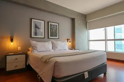 a large bed in a room with a large window at Narciso 350 by Wynwood House in Lima