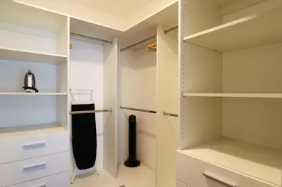 a walk in closet with white cabinets and a black umbrella at Narciso 350 by Wynwood House in Lima
