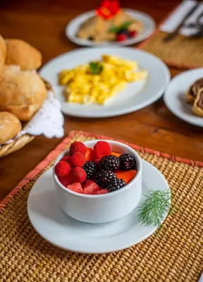 a bowl of fruit on a plate on a table at Carolina Egg Gasthaus in Oxapampa