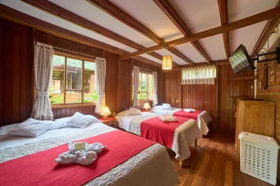 a room with two beds with red sheets at Carolina Egg Gasthaus in Oxapampa