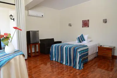 a hotel room with a bed and a tv at Casablanca Hotel in San Ramón