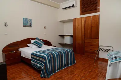 a bedroom with a bed and a wooden floor at Casablanca Hotel in San Ramón