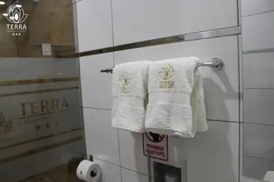 a white towel hanging on a towel rack in a bathroom at Terra Premium Hotel in Huánuco