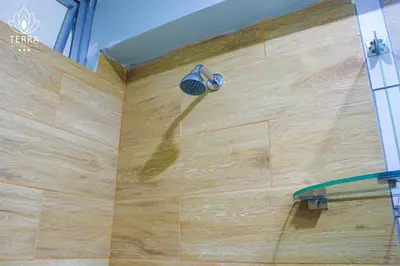 a shower with a shower head on a wooden wall at Terra Premium Hotel in Huánuco