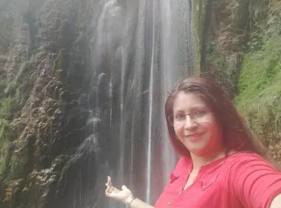 a woman standing in front of a waterfall at Casa Corazao in Urubamba