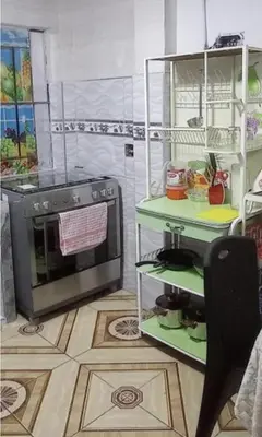 a kitchen with a stove and a microwave at LA POSADA CHASQUI Perú in Lima