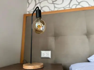 a lamp sitting on a table next to a bed at Casa Dama in Cieneguilla