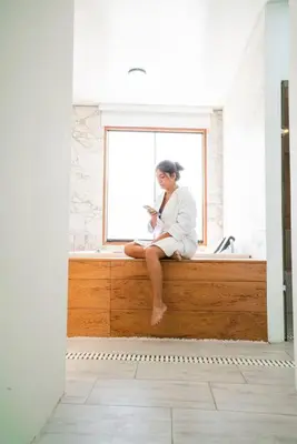 a woman sitting on a window sill in a bathroom at Casa Dama in Cieneguilla