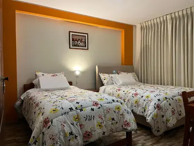 two beds in a hotel room at Hostal Inkanto Taruma in Tarma