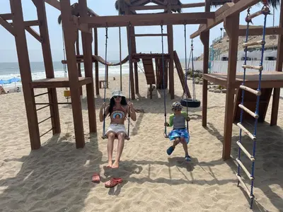 a woman and a child on a swing set on the beach at Hamacas in Punta Negra