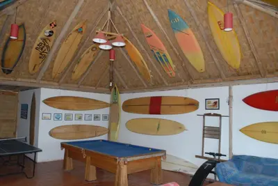 a room with a bunch of surfboards on the wall at Hamacas in Punta Negra