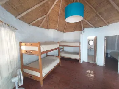 a room with two bunk beds and a blue light at Hamacas in Punta Negra