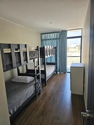 a dorm room with bunk beds and a window at Casa en Asia con piscina in Asia
