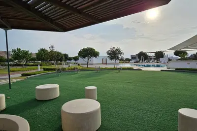 a large green field with white stools on it at Casa en Asia con piscina in Asia