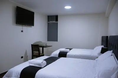 a hotel room with two beds and a flat screen tv at PRANA HOTEL LOUNGUE BAR in Huancayo
