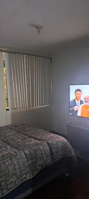 a bedroom with a bed and a flat screen tv at Acogedora Habitacion Independiente in Lima