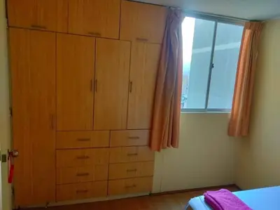 a bedroom with a large wooden chest of drawers at Tait's House - Cómodo departamento Dúplex - Ate in Lima