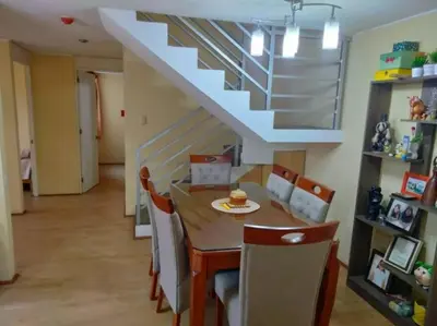 a dining room with a table and chairs and a staircase at Tait's House - Cómodo departamento Dúplex - Ate in Lima