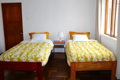 two beds sitting next to each other in a room at Inti Wasi II in Cusco