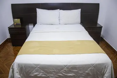 a bed with white sheets and pillows in a room at Plaza Mayor Lima in Lima