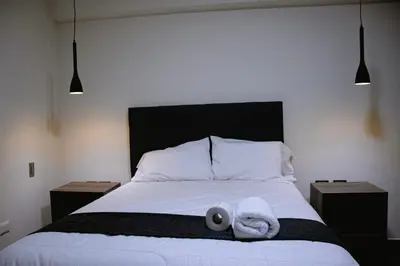 a bedroom with a bed with two towels on it at PRANA in Huancayo