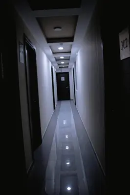 a long hallway with a dark hallway with lights at PRANA in Huancayo
