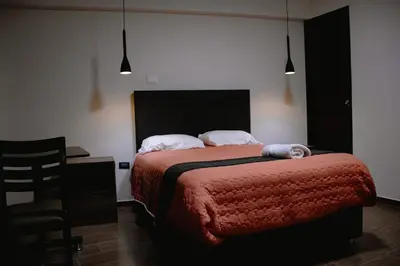 a bedroom with a bed and a desk and a chair at PRANA in Huancayo