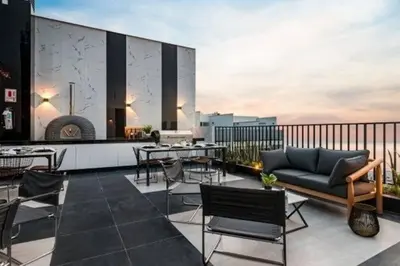 a balcony with a couch and chairs on a building at Beautiful floor 9th apartment Pool Gym Barranco in Lima