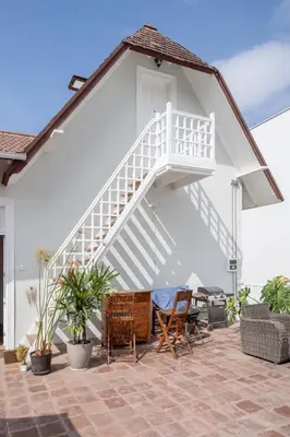 a white staircase on a house with a table and chairs at Casa Cáceres in Lima