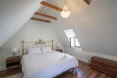 a bedroom with a white bed and wooden floors at Casa Cáceres in Lima