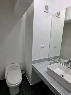 a white bathroom with a toilet and a sink at Barranco Aparment Luxury in Lima