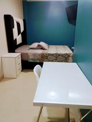 a small bedroom with a bed and a white table at HOSTAL TOSCANO SUITES in El Tambo
