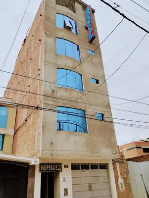 a tall brick building with a sign on it at HOSTAL TOSCANO SUITES in El Tambo