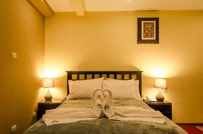 a bedroom with a bed with a pair of shoes on it at Cusco Bed and Breakfast in Cusco