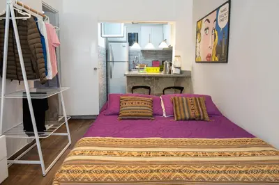 a purple bed in a room with a kitchen at Departamento Loft en Olivar de San Isidro in Lima