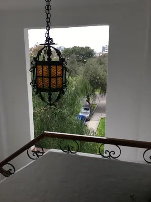 a balcony with a chandelier and a view of a yard at Departamento Loft en Olivar de San Isidro in Lima