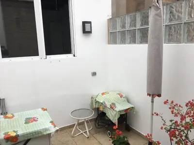 a patio with a table and chairs and windows at Departamento Loft en Olivar de San Isidro in Lima