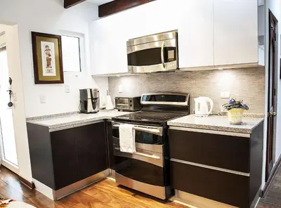 a kitchen with white cabinets and a stove top oven at Departamento Loft en Olivar de San Isidro in Lima