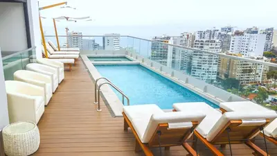 a balcony with chairs and a swimming pool on a building at Peruvian Apartments Barranco 2004 in Lima