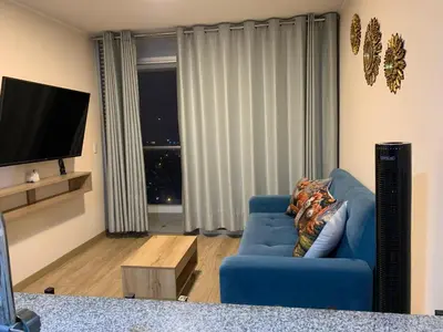 a living room with a blue couch and a television at Mousse PL in Lima