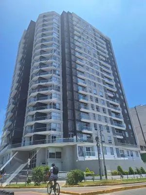 a man riding a bike in front of a tall building at Mousse PL in Lima