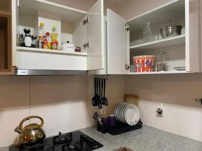 a kitchen with white cabinets and a stove top at Mousse PL in Lima