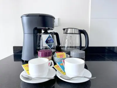 a coffee maker and two cups on a counter at Peruvian Apartments Barranco 1609 in Lima